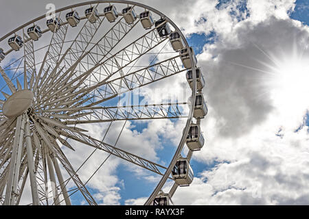 Part of a big ferris wheel on a cloudy sky background. Stock Photo