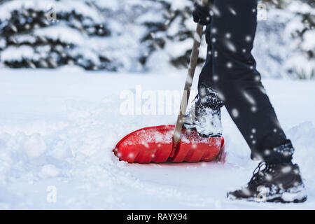 Public service worker or citizen shoveling snow during heavy winter blizzard Stock Photo