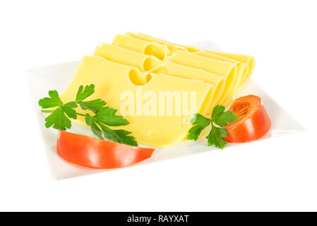 Pieces of fresh yellow cheese with parsley and tomatoes on a plate isolated on a white background in close-up. Stock Photo