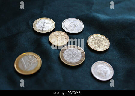 Closeup photo from above, European coins, Euro and Swiss Francs, laying on expensive looking, silky green background Stock Photo