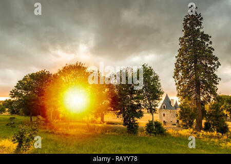 A small, hidden, pitoresk castle during a beautiful sunset on a dreamlike landscape on farmland. Stock Photo