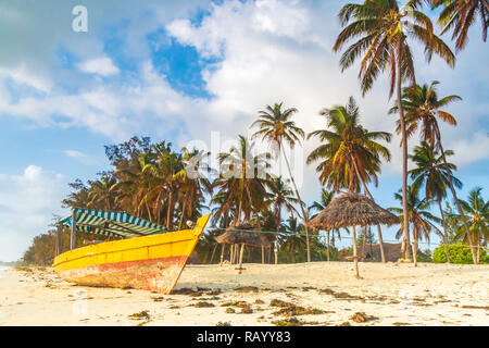Boat laying dry, stranded on a tropical beach during sunset at Zanzibar, Tanzania Stock Photo