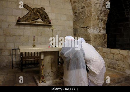 Pilgrims from Eritrea praying over an altar inside the Franciscan Catholic chapel at the 7th station of the cross along Via Dolorosa processional route in the Old City of Jerusalem, believed to be the path that Jesus walked on the way to his crucifixion. Israel Stock Photo