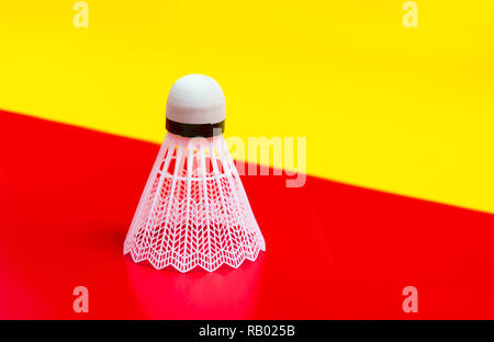 Badminton shuttlecock isolated on the red and yellow background Stock Photo