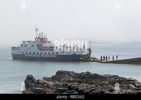 Caledonian MacBrayne Ferry. First-foot passengers of the day, arriving from Fionnphort, Mull, disembarking Quayside St. Ronan’s Bay, Isle of Iona. The Inner Hebrides. West coast of Scotland. The UK. Stock Photo