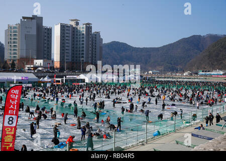 Hwacheon, South Korea. 5th Jan, 2019. People fish for trouts on a frozen river during the Sancheoneo Ice Festival in Hwacheon, South Korea, Jan. 5, 2019. As one of the biggest winter events in South Korea, the annual three-week festival draws people to the frozen Hwacheon river, where organizers drill fishing holes in the ice and release trouts into the river during the festival period. This year the festival lasts from Jan. 5 to Jan. 27. Credit: Wang Jingqiang/Xinhua/Alamy Live News Stock Photo