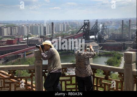 Beijing, China. 30th May, 2010. Xinhua Headlines:Steel City Still Vibrant with Olympic Rings Retired worker of Shougang Hu Yulan (R) and a photographer take pictures of the to-be-closed steel factory of Shougang Group in Beijing, capital of China, May 30, 2010. Credit: Li Wenming/Xinhua/Alamy Live News Stock Photo