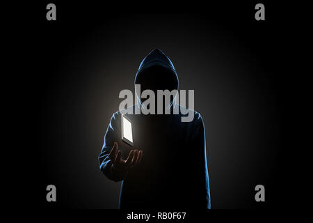 White smartphone floating above of hacker's hand in dark background. Finance, business, e-commerce or cyber crime concept Stock Photo