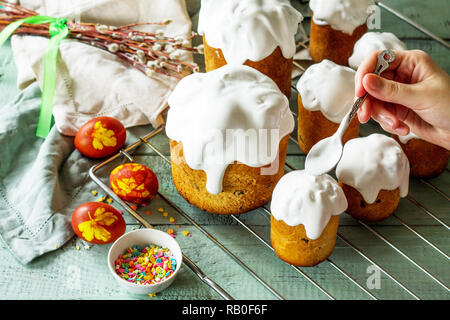 Cooking baking. Easter cake and painted eggs on white wooden table. Stock Photo