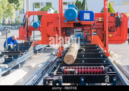 Partially milled log on a portable lumber milling machine Stock Photo