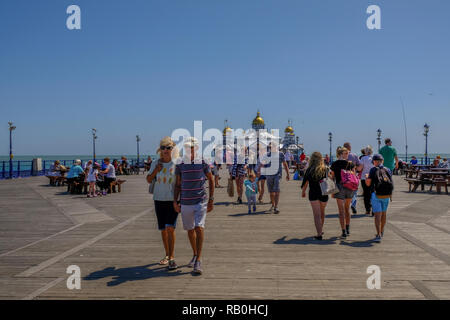 Eastbourne, Sussex, UK - August 1, 2018: People strolling on the pier at Eastbourne.  Taken on a bright sunny blue sky summer's day. Stock Photo