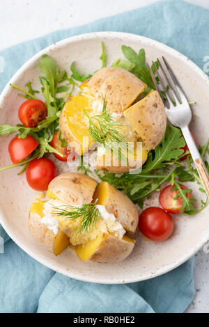 Baked potatoes stuffed with cheese and sour cream. Top view. Jacket potatoes with cheddar cheese Stock Photo