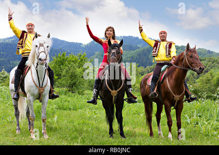 Local woman and men in traditional clothes at national folkloric games in Almaty, Kazakhstan. Stock Photo