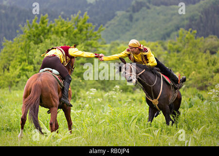 Kazakh men doing the traditional nomadic arm wrestling on their horse, in Kazakhstan. Stock Photo