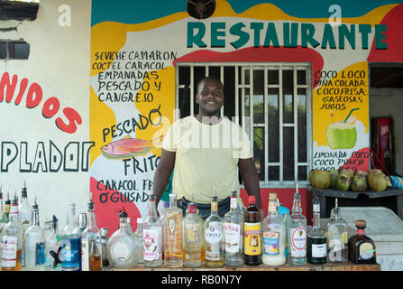 Native man selling Coco Loco (alcohol mixed coconut water) cocktails. Environmental portrait, editorial use. San Andrés, Colombia. Oct 2018 Stock Photo