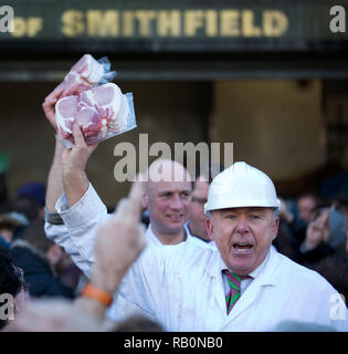 A butcher holds meat to sell during the annual Christmas Eve auction at Smithfield Market in the City of London on December 24, 2014. Stock Photo