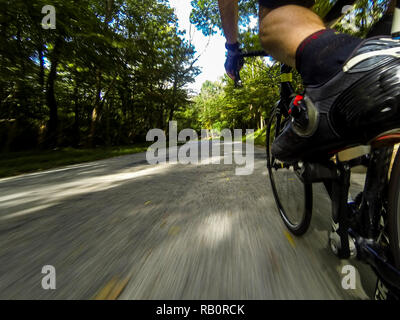 A male cyclist speeding down a hill on a road in Ohio on a road racing bike in the morning DCIM101GOPRO Stock Photo