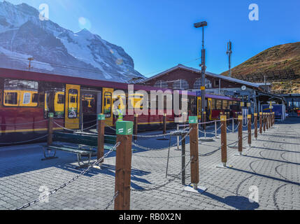 Grindelwald, Switzerland - Oct 20, 2018. Red Bernese Oberland Railway train stopping at Grindelwald train station platform. Stock Photo