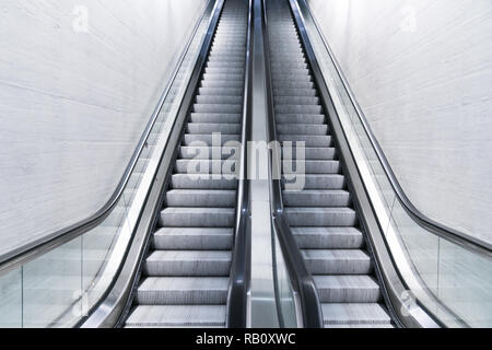 long escalator leading up in an empty train station Stock Photo
