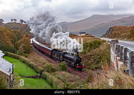 K1 steam engine No. 62034 pulls the Jacobite steam train past the famous church at Polnish at A830 en route to Mallaig from Fort William in Scotland Stock Photo