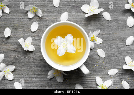 jasmine tea and jasmine flowers on wooden background. top view Stock Photo