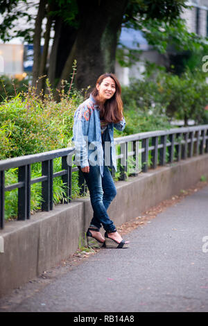 Asian female model poses for pictures on the street Stock Photo