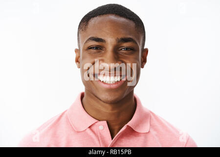Headshot of happy successful and delighted young african american male student smiling broadly with joy and delight showing perfect white teeth, enjoying life, feeling uplifted and satisfied Stock Photo