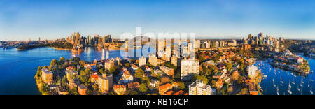 Wide aerial panorama over rooftops of residential buildings in Kirribilli suburb of Sydney with view from city CBD landmarks on harbour shores to Nort Stock Photo