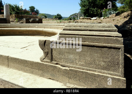 Ancient Greek inscriptions cover the sides and rear of the Exedra at the ancient Greek sanctuary of Apollo of Claros, Izmir province, Turkey.  The Exe Stock Photo