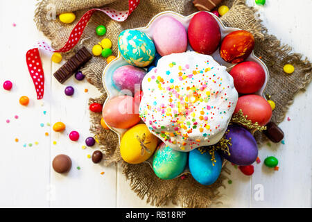Festive composition in rustic style, Easter meal Breakfast. Easter cake and painted eggs on white wooden table. Top view flat lay background. Stock Photo