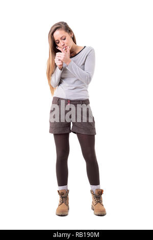 Cute long hair hipster woman with authentic style lighting up cigarette looking down. Full body isolated on white background. Stock Photo