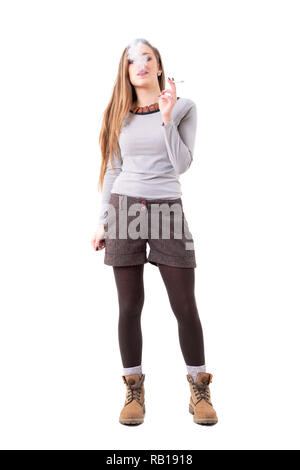 Stylish authentic hipster woman smoking rolled cigarette. Full body isolated on white background. Stock Photo