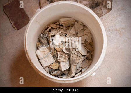 Top view of construction waste in a white plastic bucket. Bucket with construction remains Stock Photo