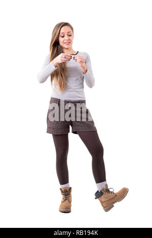 Happy candid individual cute hipster woman rolling cigarette smiling. Full body isolated on white background. Stock Photo