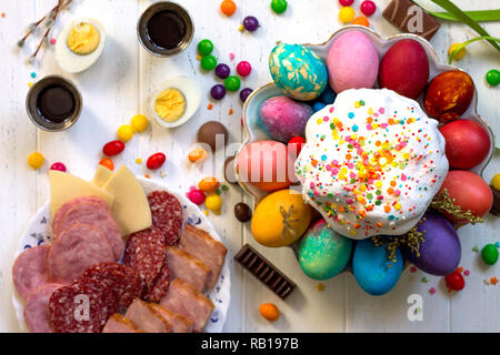 Festive composition in rustic style, Easter meal Breakfast. Easter cake and painted eggs on white wooden table. Top view flat lay background. Stock Photo