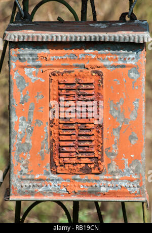 Old weathered grunge rural corroded metal post box on iron garden door closeup Stock Photo