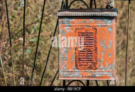 Old weathered grunge rural corroded metal post box on iron garden door closeup Stock Photo