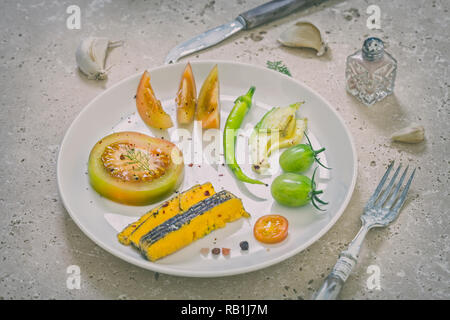 Various vegetables and Shropshire blue cheese arranged on white plate on beige rustic table top. Close-up Stock Photo