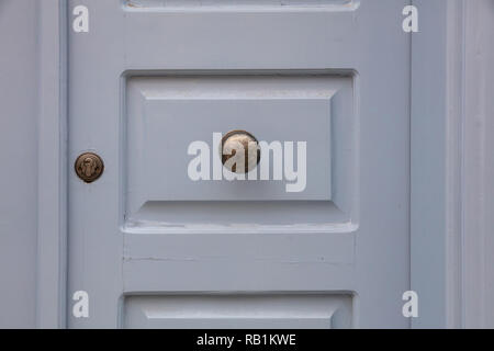 Old brass door knob on a gray painted wooden entrance door, residential building in old town Plaka, Athens Greece Stock Photo