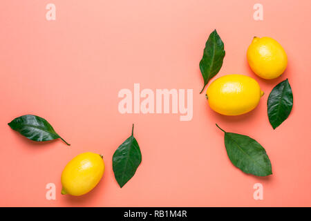 Living coral background with ripe lemons. Flat lay style. Stock Photo