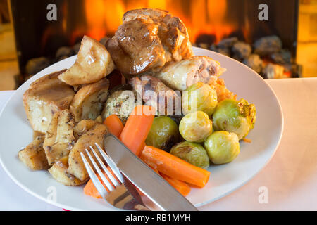A popular British roast Chicken Sunday dinner with Yorkshire pudding, Stuffing, Pigs in blankets and potato and vegetables. Stock Photo