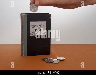 Vintage swear box, with UK coins, money and hand. Stock Photo