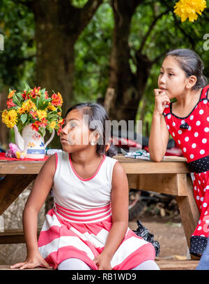 latin kids sitting at picnic table at party in Guatemala Stock Photo