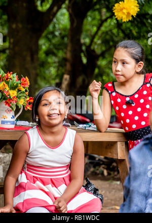 latin kids sitting at picnic table at party in Guatemala Stock Photo