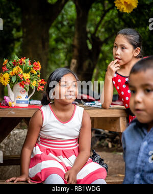 latin kids sitting at picnic table at party in Guatemala Stock Photo