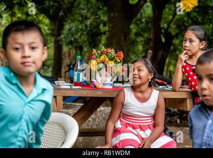 latin kids sitting at picnic table at party in Guatemala Stock Photo