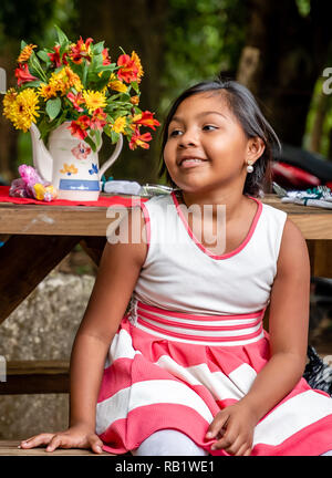 latin kids sitting at picnic table at party in Guatemala Stock Photo