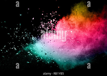 Color powder explosion cloud on black background. Freeze motion of color dust  particles splashing. Stock Photo