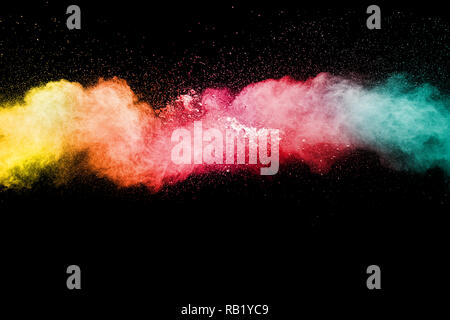 Color powder explosion cloud on black background. Freeze motion of color dust  particles splashing. Stock Photo