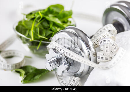 Spinach dumbbells and measure tape isolated on white background. Stock Photo